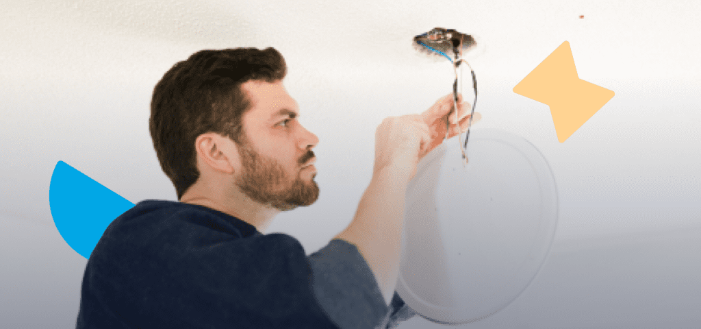 A man is examining a device on the ceiling and managing electrical issues for rental properties.