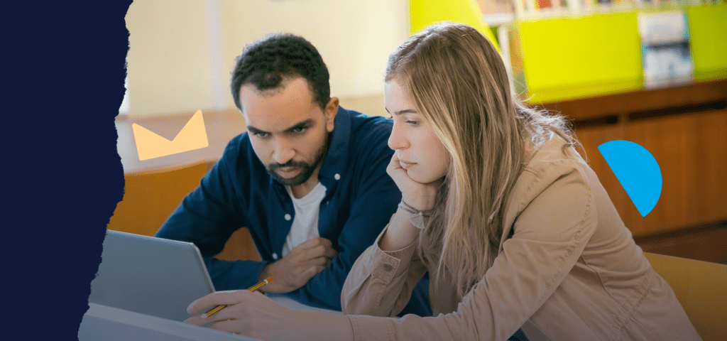Two people sitting and looking at a laptop