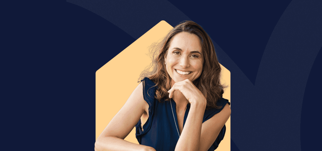 A smiling woman with her chin resting on her hand